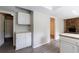 Open-concept kitchen features white cabinets and counters, light gray flooring, and transitions to a brick fireplace room at 135 Pheasant Se Dr, Marietta, GA 30067