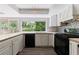 Kitchen featuring white cabinets, black appliances, and backyard views at 135 Pheasant Se Dr, Marietta, GA 30067