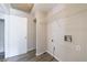 Well-lit laundry room with gray wood-look flooring, white walls, a wire rack shelf, and utility hookups at 135 Pheasant Se Dr, Marietta, GA 30067