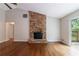 Bright living room with hardwood floors, brick fireplace, and sliding door access to the deck at 135 Pheasant Se Dr, Marietta, GA 30067
