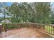 Wet wooden back deck overlooking a yard with lush trees and greenery at 1709 Grove Se Ct, Conyers, GA 30013
