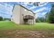 A backyard featuring a deck, expansive green lawn, and mature trees in a residential neighborhood at 1709 Grove Se Ct, Conyers, GA 30013
