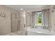 Bathroom featuring walk-in shower and soaking tub at 1709 Grove Se Ct, Conyers, GA 30013