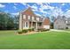 Charming two-story brick home with a well-manicured lawn, front porch, and attached garage at 1709 Grove Se Ct, Conyers, GA 30013