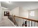 Bright hallway features wood and iron railing, plush carpeting, and a view into the spacious bedroom at 1709 Grove Se Ct, Conyers, GA 30013