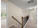 Upstairs hallway with a wooden railing and neutral walls leading to multiple rooms at 1709 Grove Se Ct, Conyers, GA 30013