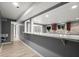 A kitchen area featuring wood cabinets, granite countertop bar, light wood floors, and access to a living area at 1709 Grove Se Ct, Conyers, GA 30013