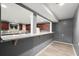 A modern kitchen area with wood cabinets, a granite countertop bar, light wood floors, and gray accent walls at 1709 Grove Se Ct, Conyers, GA 30013
