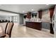 Spacious kitchen featuring dark wood cabinets, light floors, stone backsplash, and an open view into the living room at 1709 Grove Se Ct, Conyers, GA 30013