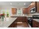 Well-lit kitchen with stainless steel appliances, granite countertops, and wood cabinets at 1709 Grove Se Ct, Conyers, GA 30013