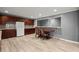 A kitchen area with wood cabinets, light wood floors, stone backsplash, and a unique eat-in bar with two chairs at 1709 Grove Se Ct, Conyers, GA 30013