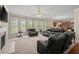 Open living room with a ceiling fan, fireplace, and multiple windows at 1709 Grove Se Ct, Conyers, GA 30013