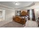 Spacious primary bedroom featuring tray ceiling, carpet floors, and elegant furniture at 1709 Grove Se Ct, Conyers, GA 30013