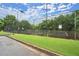 View of community tennis courts surrounded by trees and fencing at 1709 Grove Se Ct, Conyers, GA 30013