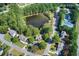 Aerial view of a neighborhood with a pond, tennis court, and tree-lined streets at 1870 Milfield Cir, Snellville, GA 30078