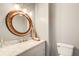 Stylish half-bathroom featuring a marble vanity, decorative mirror, and modern lighting at 1870 Milfield Cir, Snellville, GA 30078