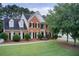 Traditional two-story brick home with a well-manicured lawn and mature trees at 1870 Milfield Cir, Snellville, GA 30078