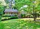 Beautiful home featuring a lush green lawn, brick facade, and manicured landscaping at 7310 Ne Wynhill Ne Dr, Atlanta, GA 30328
