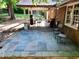 A private patio with bluestone pavers, outdoor seating, and mature landscaping at 7310 Ne Wynhill Ne Dr, Atlanta, GA 30328