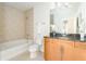 Bright bathroom features vanity with countertop, tiled shower, and white fixtures at 855 Peachtree Ne St # 2913, Atlanta, GA 30308