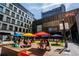 Vibrant town square with colorful umbrellas, outdoor seating, and modern buildings in the background at 855 Peachtree Ne St # 2913, Atlanta, GA 30308