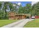 Exterior shot of home with long driveway featuring wood siding, and a covered carport at 860 The Cir, Lawrenceville, GA 30043