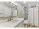 Bathroom with white vanity, marble countertop, gold fixtures, and patterned shower tile at 443 Langley Oaks Dr, Marietta, GA 30067