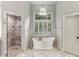 Bright bathroom boasts marble floors, a soaking tub under a window, and a separate shower at 443 Langley Oaks Dr, Marietta, GA 30067