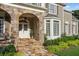 Inviting front porch with stone pillars, decorative lighting, and well-maintained landscaping at 443 Langley Oaks Dr, Marietta, GA 30067