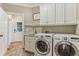 Well-equipped laundry room with modern front-load washer and dryer, sink, and storage cabinets at 443 Langley Oaks Dr, Marietta, GA 30067