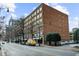 Exterior daytime view of a red brick building with numerous windows, street parking and city skyline view at 800 Peachtree Ne St # 8607, Atlanta, GA 30308
