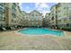 Apartment complex featuring a spacious pool surrounded by lounge chairs and manicured greenery at 800 Peachtree Ne St # 8607, Atlanta, GA 30308