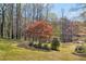 The lush backyard leads to a lake with a wooden dock and a ' playset at 10845 Shallowford Rd, Roswell, GA 30075
