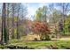 The spacious backyard with mature trees offers a serene setting for outdoor activities at 10845 Shallowford Rd, Roswell, GA 30075