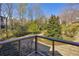 View of the spacious backyard from the deck, featuring mature trees and lush greenery at 10845 Shallowford Rd, Roswell, GA 30075