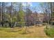 Spacious backyard with access to a lake, featuring a picnic area and a wooden dock at 10845 Shallowford Rd, Roswell, GA 30075