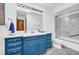 Bathroom with a blue vanity with sink, toilet, and shower with glass doors at 10845 Shallowford Rd, Roswell, GA 30075