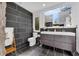 Modern bathroom with large gray tile wall, dual sink vanity, and bright window at 10845 Shallowford Rd, Roswell, GA 30075