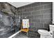 Modern bathroom with a glass shower featuring black and marble tile, along with a wooden towel rack at 10845 Shallowford Rd, Roswell, GA 30075