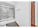 Bathroom with a toilet and shower with glass doors and grab bars, tiled with grey and white at 10845 Shallowford Rd, Roswell, GA 30075