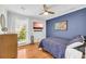 Comfortable bedroom with a plush bed, wooden floors, and a large window offering natural light at 10845 Shallowford Rd, Roswell, GA 30075