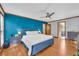 Bright bedroom with hardwood floors, blue accent wall, and comfortable bed and ceiling fan at 10845 Shallowford Rd, Roswell, GA 30075