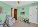 Bright bedroom with mint green walls and a cozy chair near a toddler's table at 10845 Shallowford Rd, Roswell, GA 30075