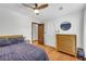 Well-lit bedroom featuring hardwood floors, dresser, and a stylish ceiling fan, creating a cozy ambiance at 10845 Shallowford Rd, Roswell, GA 30075