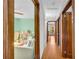 Bright hallway leading to a cozy bedroom with a white crib and soft pastel-colored walls at 10845 Shallowford Rd, Roswell, GA 30075