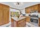 Charming kitchen with oak cabinets, stainless steel appliances, granite counters, and a kitchen island at 10845 Shallowford Rd, Roswell, GA 30075