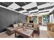 Spacious living room featuring dark paneled walls, a large couch and bright lighting at 10845 Shallowford Rd, Roswell, GA 30075