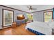 Spacious main bedroom with hardwood floors, large windows, and a dresser under a wall-mounted TV at 10845 Shallowford Rd, Roswell, GA 30075