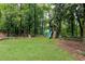 Expansive backyard featuring a playset, lush greenery, and a well-maintained lawn, perfect for outdoor activities at 1329 W Nancy Creek Ne Dr, Brookhaven, GA 30319
