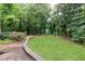 Serene backyard featuring a lush lawn area and playground, nestled among mature trees for a private retreat at 1329 W Nancy Creek Ne Dr, Brookhaven, GA 30319